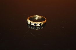 A HALLMARKED 9 CARAT GOLD SEVEN STONE DRESS RING - SIZE O - WEIGHT 1.4 GRAMS APPROX