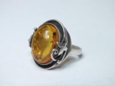 A LARGE SILVER MOUNTED AMBER RING