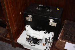 A SMALL CASED ELECTRIC 221K SINGER SEWING MACHINE