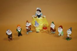 A DISNEY CERAMIC SNOW WHITE AND THE SEVEN DWARVES FIGURE SET TOGETHER WITH A DISNEY WINNIE THE