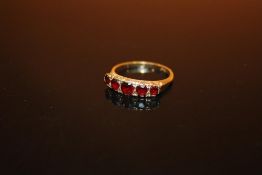 A HALLMARKED 9 CARAT GOLD FIVE STONE GARNET DRESS RING - SIZE N 1/2 - WEIGHT 2.3 GRAMS APPROX
