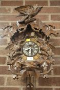 A CARVED BLACK FOREST STYLE CUCKOO CLOCK WITH WEIGHTS AND PENDULUM