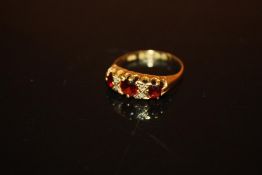 AN 18 CARAT GOLD THREE STONE GARNET DRESS RING - SIZE M - WEIGHT 2.4 GRAMS APPROX