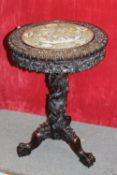 AN ORIENTAL CARVED PEDESTAL OCCASIONAL TABLE, the shaped top having an inset famille rose circular