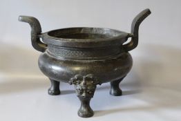 A LARGE ORIENTAL BRONZED TWIN HANDLED CENSOR, the outswept handles leading from a patterned