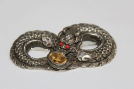 A VINTAGE WHITE METAL CHINESE DRAGON TYPE BROOCH, set with a citrine style stone by the mouth and