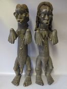 A PAIR OF WEST AFRICAN CARVED TRIBAL FIGURES, depicting a man and woman in traditional dress, H 62
