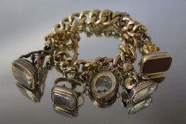 A GOLD FOB SEAL CHARM BRACELET, the bracelet stamp is indistinct but possibly 15ct, set with four