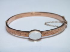 A HALLMARKED 9 CT ROSE GOLD BANGLE, set with a moonstone, approx weight 7.6g