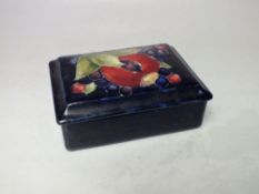 A MOORCROFT POMEGRANATE PATTERN RECTANGULAR LIDDED BOX, with typical tubelined decoration, paper