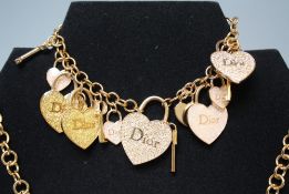 A COLLECTION OF CHRISTIAN DIOR COSTUME JEWELLERY TO INCLUDE A CHARM BRACELET, floral bracelet, heart