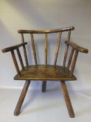 A CHILDS PRIMITIVE ELM STICKBACK ARMCHAIR, of naive construction, the curved top rail over a