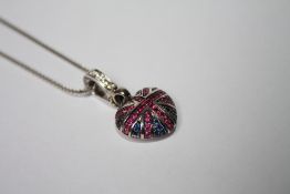 A THEO FENNELL OF LONDON 18CT WHITE GOLD UNION JACK HEART SHAPED PENDANT WITH RUBIES, SAPPHIRES