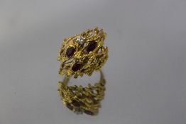 AN UNUSUAL NATURALISTIC DESIGNER STYLE RING, stamped 18ct and set with three rubies and a diamond,