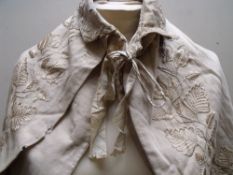 AN EARLY 20TH CENTURY LADIES DOUBLE CAPE WITH EMBROIDERED EMBELLISHMENT
