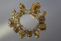 A HALLMARKED 9 CT GOLD CHARM BRACELET, set with ten charms, majority hallmarked 9 carat, approx