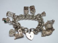 A HALLMARKED SILVER HEAVY LINK CHARM BRACELET WITH CHARMS, the links individually stamped with