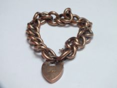 A YELLOW METAL CHAIN LINK / CHARM BRACELET WITH HEART SHAPED CLASP, the clasp and links individually