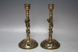 A PAIR OF ORIENTAL BRASS CANDLESTICKS, each with pierced raised bases, leading to stylised columns