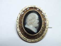AN UNUSUAL CAMEO BROOCH, with black enamel type background, unmarked yellow metal, W 2.5 cm