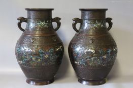 A PAIR OF ORIENTAL BRONZED BALUSTER SHAPED VASES, small areas of enamel decoration, character