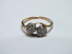 AN 18CT GOLD AND DIAMOND EDWARDIAN TWIST BAND FLORAL RING, each flower with seven illusion set
