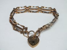 A HALLMARKED 9CT GOLD THREE BAR GATE BRACELET, with heart shaped clasp and safety chain, approx. 8.