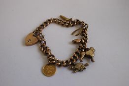A 9ct GOLD AND YELLOW METAL CHARM BRACELET, charms include an 1853 USA $1