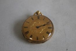 A YELLOW METAL FOB WATCH (marked 18ct), gilt engraved dial with black Roman Numeral markings.