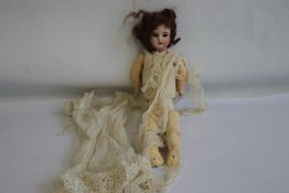 AN ANTIQUE FRENCH BISQUE HEADED DOLL, marked Paris to the back of the head and composition body A/