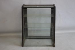 A VINTAGE GLASS AND WOOD SHOP COUNTER DISPLAY CABINET, fitted with three shelves and a sloping front
