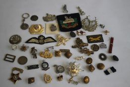 A BOX OF MILITARY BADGES AND BUTTONS, to include cap badges and cloth badges