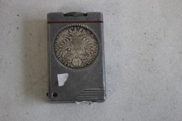 A VINTAGE LIFT ARM LIGHTER, inset with two Austrian Restrike Thaller Coins