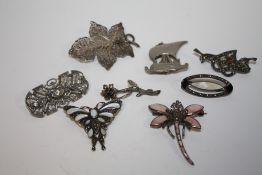 A BAG OF MOSTLY SILVER BROOCHES TO INCLUDE A DRAGONFLY SHAPED EXAMPLE (8)