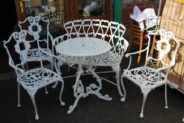A CIRCULAR GARDEN TABLE WITH A BENCH AND 3 CHAIRS