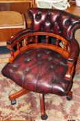 A REPRODUCTION OXBLOOD LEATHER OFFICE SWIVEL CHAIR