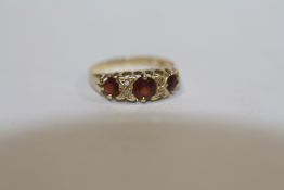 AN 18 CARAT GOLD THREE STONE GARNET DRESS RING - SIZE M - WEIGHT 2.4 GRAMS APPROX