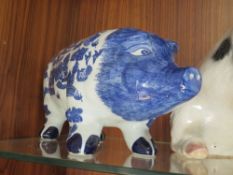A LARGE FIGURE OF A SEATED PIG, TOGETHER WITH A BLUE AND WHITE PIGGY BANK OF LARGE PROPORTIONS (2)