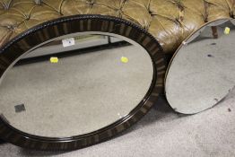 A CIRCULAR BEVEL EDGED WALL MIRROR TOGETHER WITH AN OVAL MIRROR