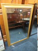 A LARGE GILT FRAMED BEVEL EDGED WALL MIRROR