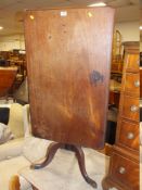 AN ANTIQUE MAHOGANY TILT-TOP PEDESTAL TABLE