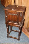 A SMALL OAK LINENFOLD BEDSIDE CABINET