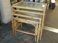 A NEST OF THREE BAMBOO GLASS TOPPED TABLES
