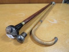 A HALLMARKED SILVER TOPPED WALKING CANE, TOGETHER WITH ANOTHER AND A WHITE METAL BANDED WALKING