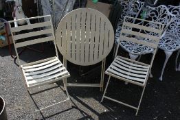 A FOLD-UP METAL GARDEN TABLE AND 2 CHAIRS