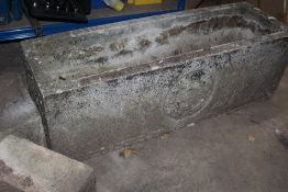 A RECTANGULAR STONE PLANTER WITH FLORAL DESIGN ON RAISED FEET