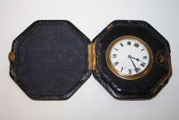 AN ANTIQUE LEATHER FITTED CASED TRAVEL WATCH