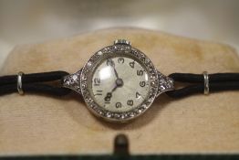 A LADIES VINTAGE PLATINUM AND DIAMOND SET WATCH - EACH BRILLIANT CUT DIAMOND APPROX 0.02 CARATS -