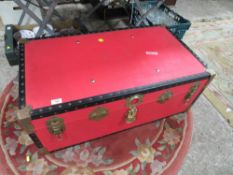 A LARGE RED STUDDED PACKING TRUNK