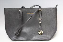A MICHAEL KORS BLACK TEXTURED LEATHER TOTE BAG, two flat leather handles, gold-tone hardware, zip